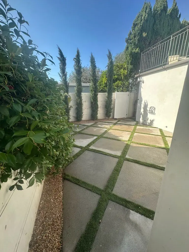 High-end paver and turf grid courtyard with sculpted cypress hedging installed by Operational Gardener, a veteran-owned landscaper in Torrance and the South Bay